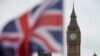 A Union flag flies in the wind in front of the Big Ben clock face and the Elizabeth Tower at the Houses of Parliament in central London